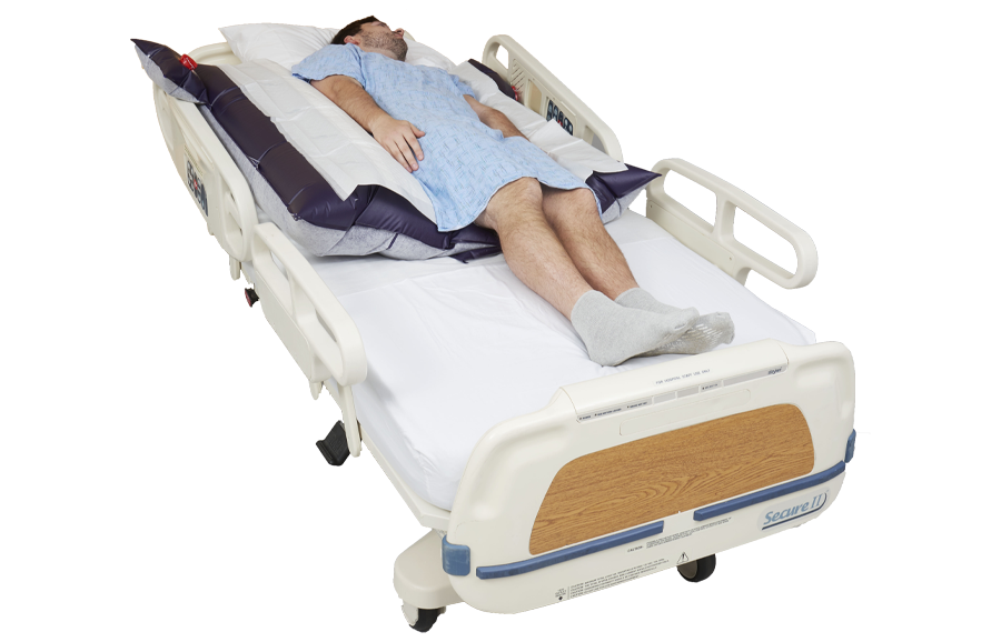 Patient lying on a hospital bed on top of a Q2Roller and Q2R Pad